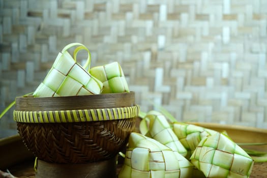 Group of empty ketupat on bamboo tray for Idul Fitri or Eid Mubarak in Indonesia. Copy space.
