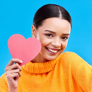 Paper heart, smile and portrait of woman in studio, blue background and backdrop. Happy female model, love shape and care of trust, support and thank you for kindness, valentines day and emoji icon.