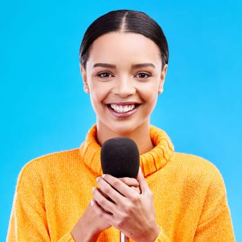 Happy, microphone and portrait of woman in studio for singing, karaoke and journalist. Reporter, news announcement and media with female on blue background for information, interview or communication.
