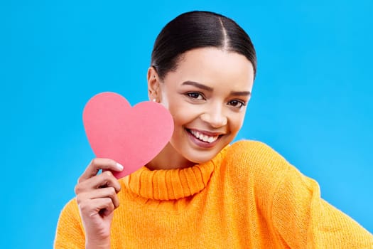 Paper heart, happy woman and portrait on blue background, studio and backdrop. Female model, smile and shape of love, trust and support of peace, thank you and kindness on valentines day for romance.