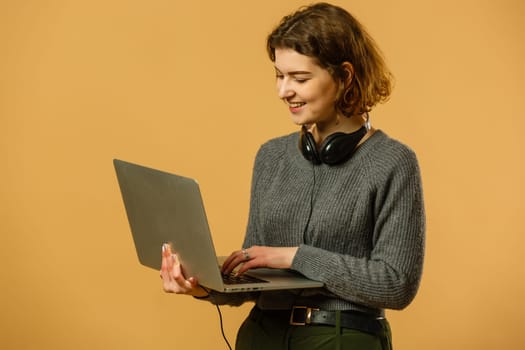 Portrait of intelligent cheerful lady skilled executive assistant holding in hand laptop working remotely isolated bright beige color background.