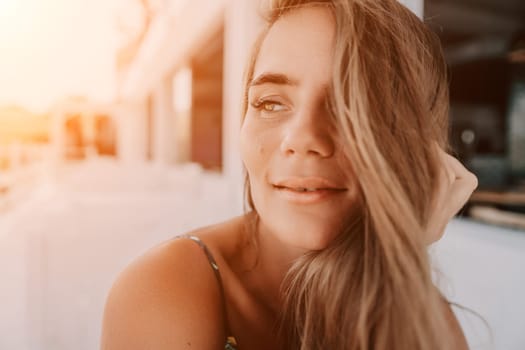 Happy woman portrait in cafe. Boho chic fashion style. Outdoor photo of young happy woman with long hair, sunny weather outdoors sitting in modern cafe