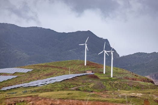 A picturesque sky filled with clouds embracing a wind farm of majestic turbines, powering our world in an environmentally-friendly manner. Madeira, Portugal