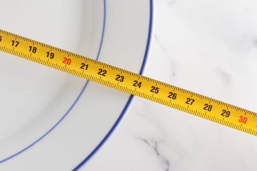 Size of white plate on a white background, measuring tape