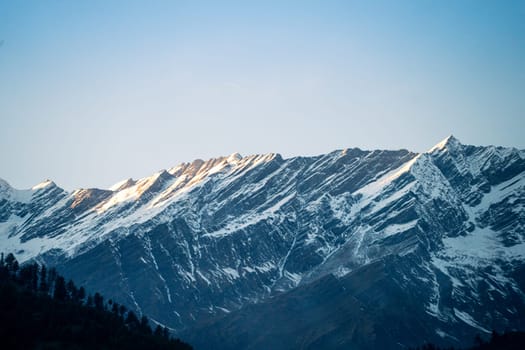 rocky himalayan peaks with snow covering the top against the blue sky showing the beauty of leh ladakh spiti valley in India