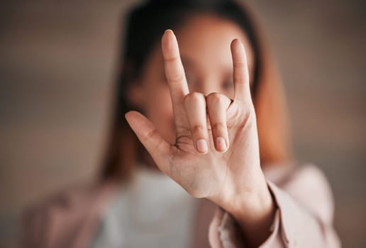 Hand, sign language and love with a person closeup in studio on a blurred background for communication. Emoji, icon or affection and an adult indoor to gesture romance with a fingers icon signal.