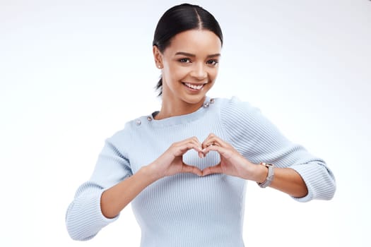 Portrait, heart and hand gesture with a woman on a white background isolated in studio for health or love. Face, hands and emoji with an attractive young female indoor for romance or valentines day.
