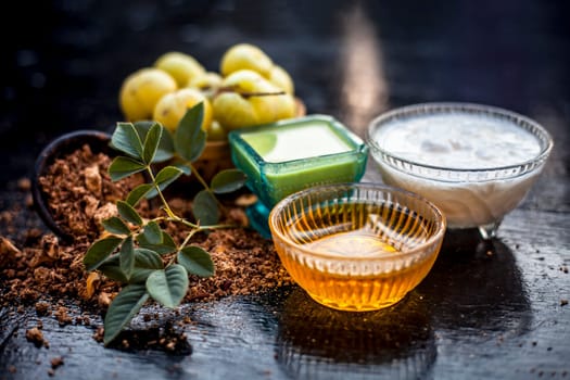 Close-up of herbal face pack of Indian gooseberry or amla with curd or yogurt and honey in a glass bowl on the wooden surface used to have instant bright skin.