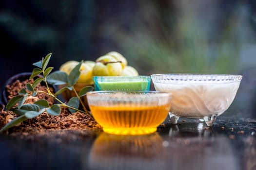 Close-up of herbal face pack of Indian gooseberry or amla with curd or yogurt and honey in a glass bowl on the wooden surface used to have instant bright skin.