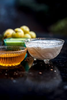 Close-up of herbal face pack of Indian gooseberry or amla with curd or yogurt and honey in a glass bowl on the wooden surface used to have instant bright skin.