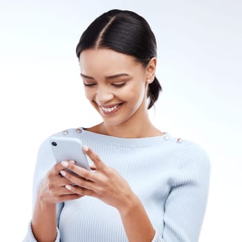 Phone, typing and happy woman isolated on a white background for social media, funny meme or internet chat. Young person networking, communication or reading news or post on mobile app in studio.