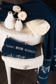 A vertical shot of a bathroom cabine with a drawer with navy blue bamboo towels