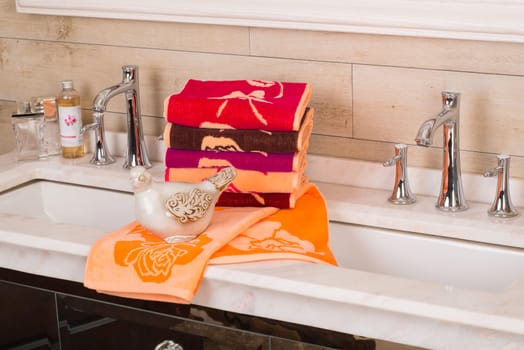 A closeup shot of folded colorful bamboo towels on a decorative bathroom cabinet