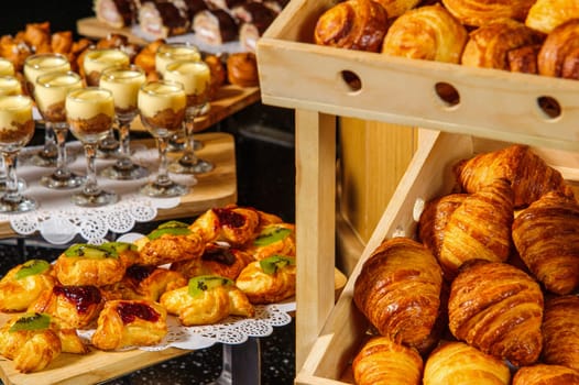 A buffet table with wooden baskets full of croissants for product exhibition