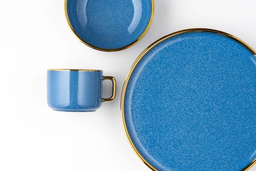 A set of blue ceramic plates and cup on a white background. Top view