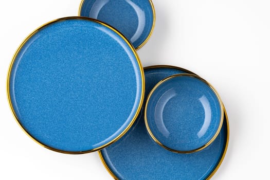 A set of blue ceramic plates on a white background. Top view