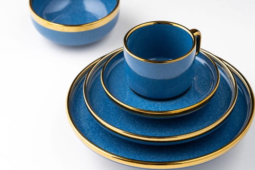 A set of blue ceramic plates and cup on a white background