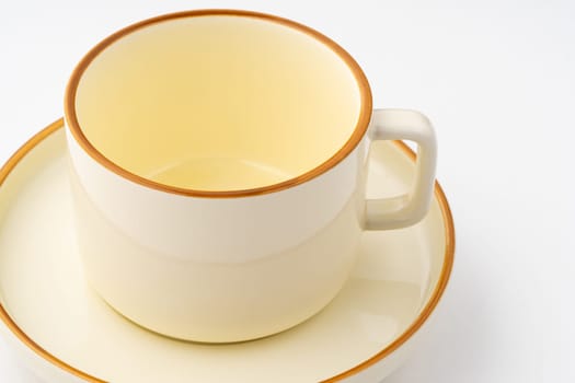 A set of white and brown ceramic plate and cup on a white background