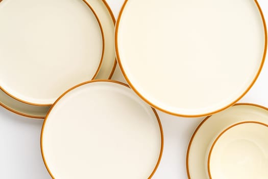 A set of white and brown ceramic plates on a white background. Top view