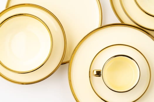 A set of golden luxury ceramic kitchen utensils on a white background