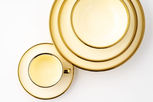 A set of golden luxury ceramic kitchen utensils on a white background