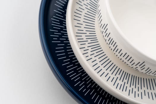 A closeup shot of a blue and white mug on a saucer with a white background