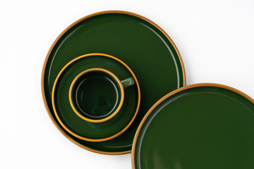 A set of dark green ceramic tableware with orange outlines