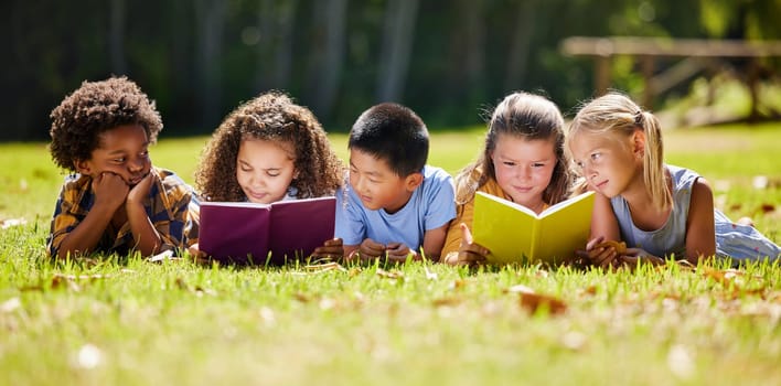 Children, books and lying in park with friends, learning or diversity for reading at school playground. Kids, education or study with support, mockup space or solidarity at multicultural kindergarten.