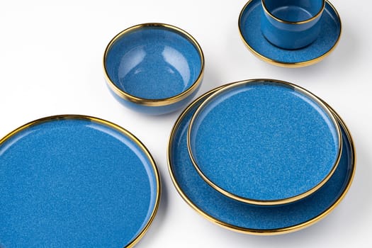 A set of blue ceramic plates and cup on a white background