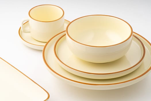 A set of white and brown ceramic plate and cup on a white background