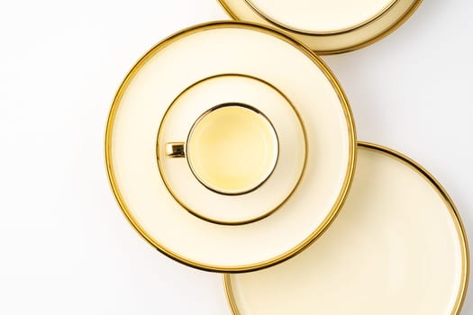 A set of golden luxury ceramic kitchen utensils on a white background