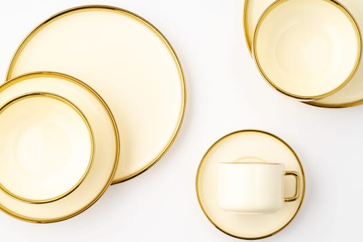 A set of golden luxury ceramic kitchen utensils on a white background