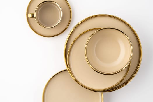 A Set of light brown ceramic plate and cup on a white background. Top view