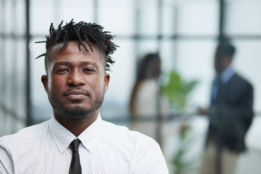 Handsome businessman frowning at camera in his office