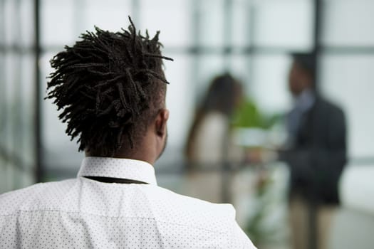 Portrait of a middle-aged african man standing with his back