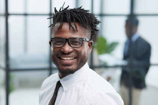 Close-up portrait of smiling handsome african american businessman in white shirt