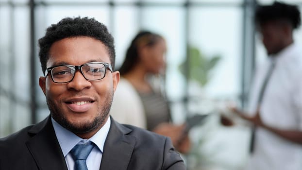 Attractive guy with a charming smile and glasses with arms folded in front