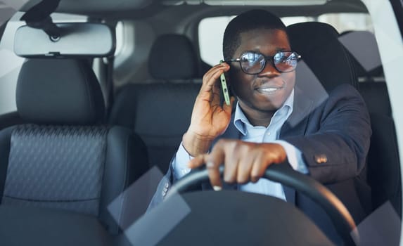 Front view. Young african american businessman in black suit is in the automobile.