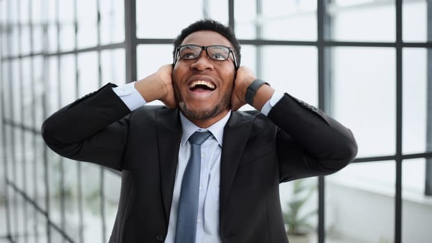 Photo of a young excited guy rejoicing in his luck in a black suit