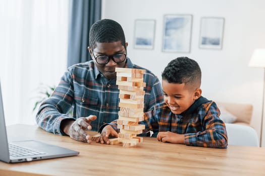 Playing together. African american father with his young son at home.