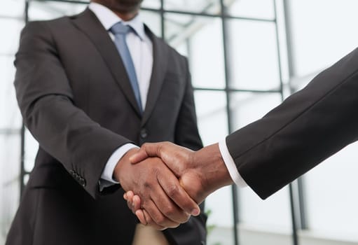 Shot of a young businessman shaking hands with a colleague in the office