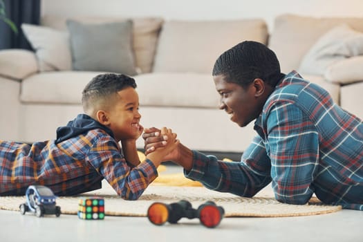 Side view. African american father with his young son at home.