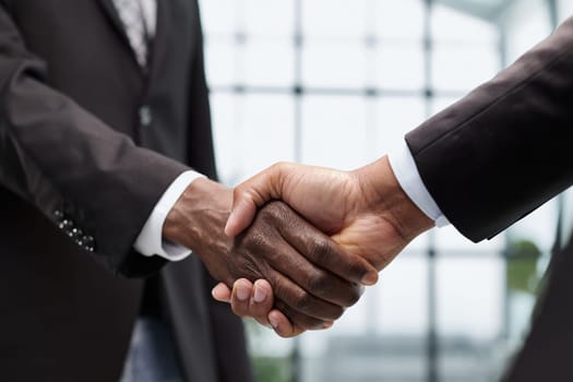 young businessmen shaking hands in the office close-up