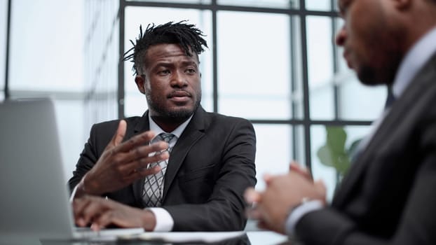 Confident male lawyer discussing project with businessman during office meeting