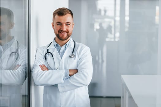 Front view. Professional medic in white coat is in the clinic.