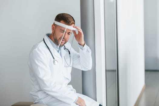 Feeling bad and tired. Professional medic in white coat is in the clinic.