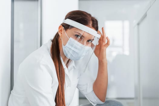 Having headache. Professional medic in white coat is in the clinic.