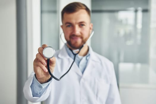 Focused image. Professional medic in white coat is in the clinic.