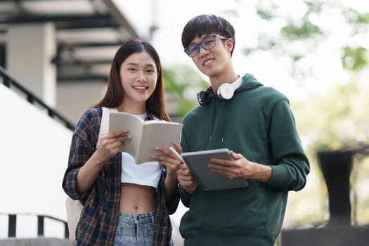 Young Asian woman college student with friends at outdoors. College student working on the college campus, education, school, study.