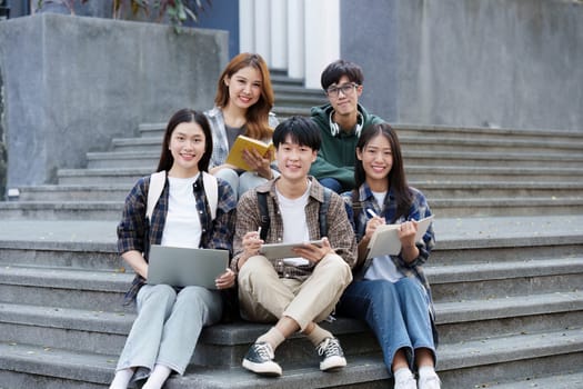 Young Asian woman college student with friends at outdoors. College student working on the college campus, education, school, study.